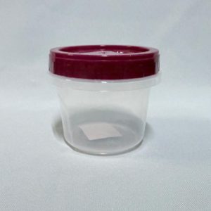 Pote redondo pequeño de plástico transparente con tapa a rosca color bordó, visto en ángulo desde arriba sobre un fondo blanco.